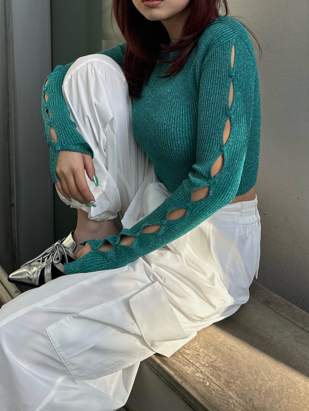 グリーン系のニット/セーター、ホワイト系のその他パンツ、シルバー系のサンダルを着用したレディースの冬コーディネートの4枚目の写真