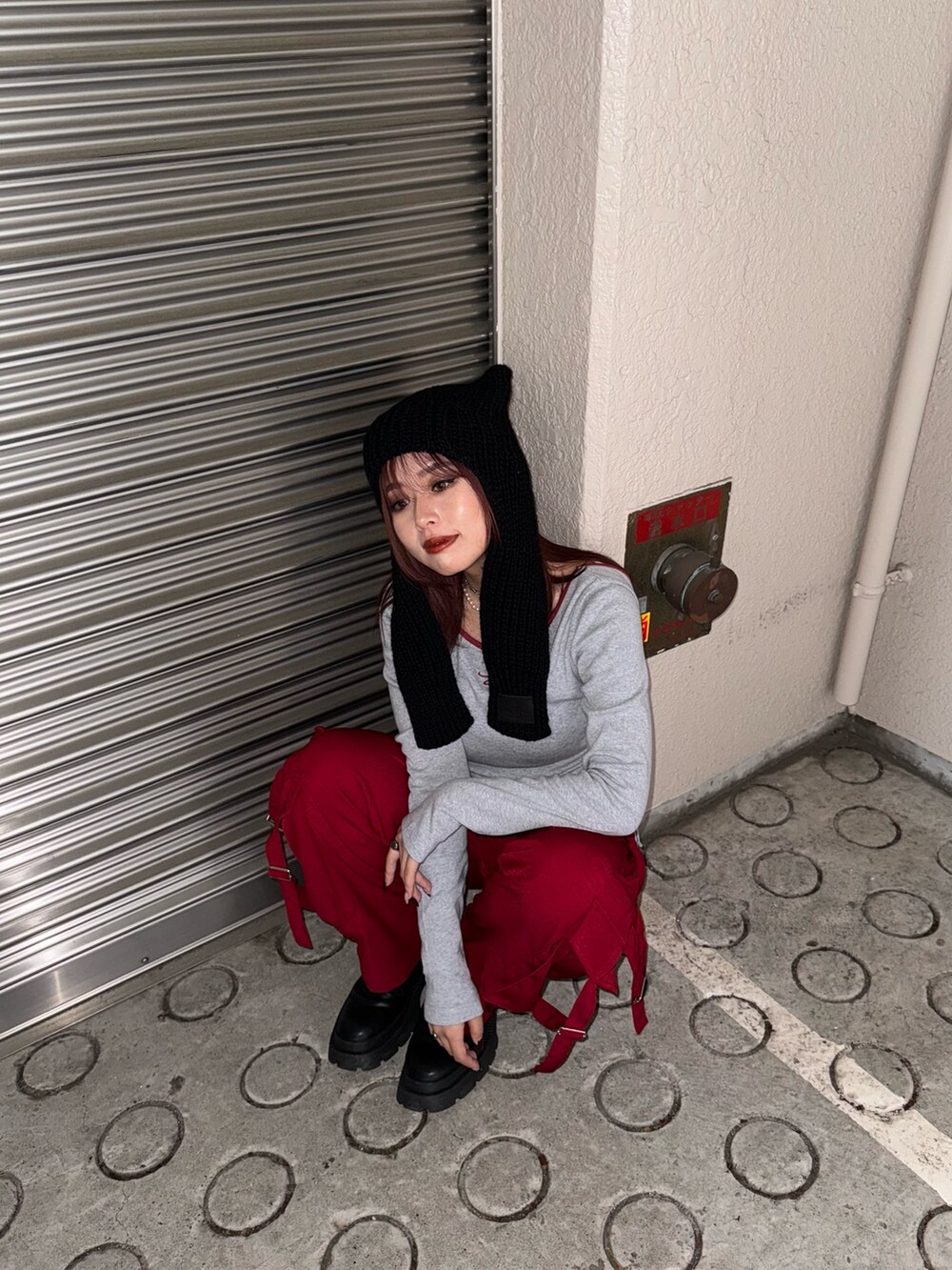 グレー系のTシャツ/カットソー、レッド系のカーゴパンツ、ブラック系のブーツを着用したレディースの秋コーディネートの5枚目の写真
