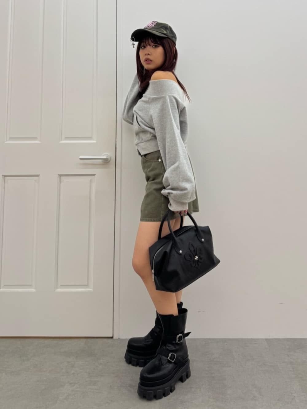 ブラック系のボストンバッグ、ブラック系のブーツ、グレー系のスウェットを着用したレディースの冬コーディネートの2枚目の写真