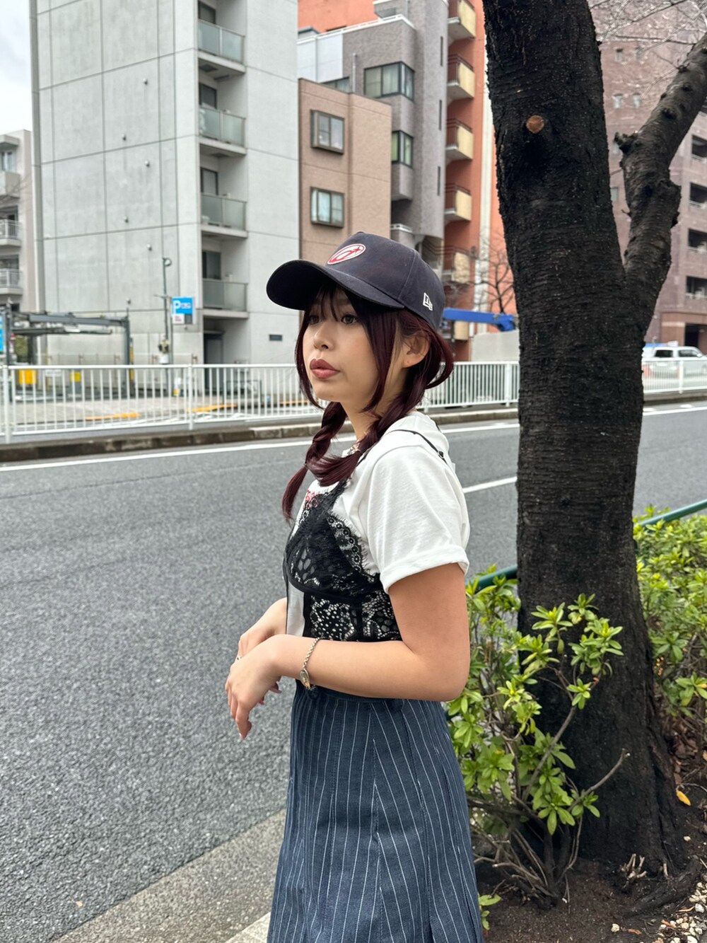 ホワイト系のTシャツ/カットソー、ブラック系のキャミソール、ブルー系のデニムスカートを着用したレディースの春コーディネートの2枚目の写真