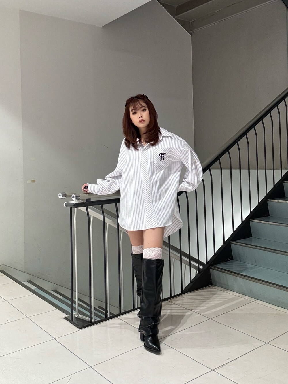 ホワイト系のシャツ/ブラウス、ブラック系のブーツを着用したレディースの冬コーディネートの2枚目の写真