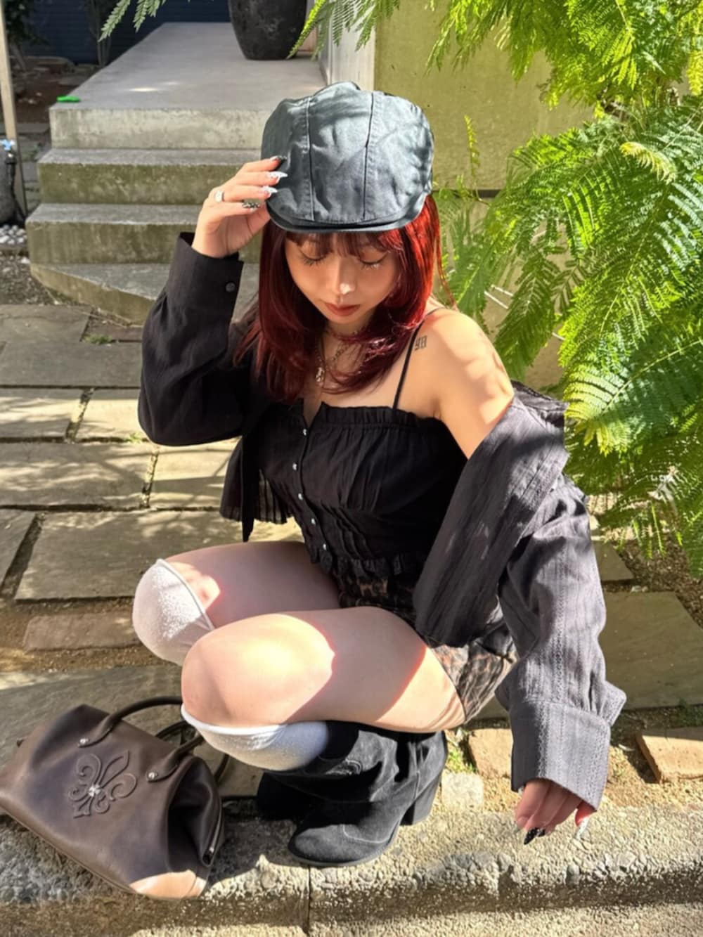 ブラウン系のボストンバッグ、ブラック系のブーツ、その他のその他パンツを着用したレディースの春コーディネートの4枚目の写真