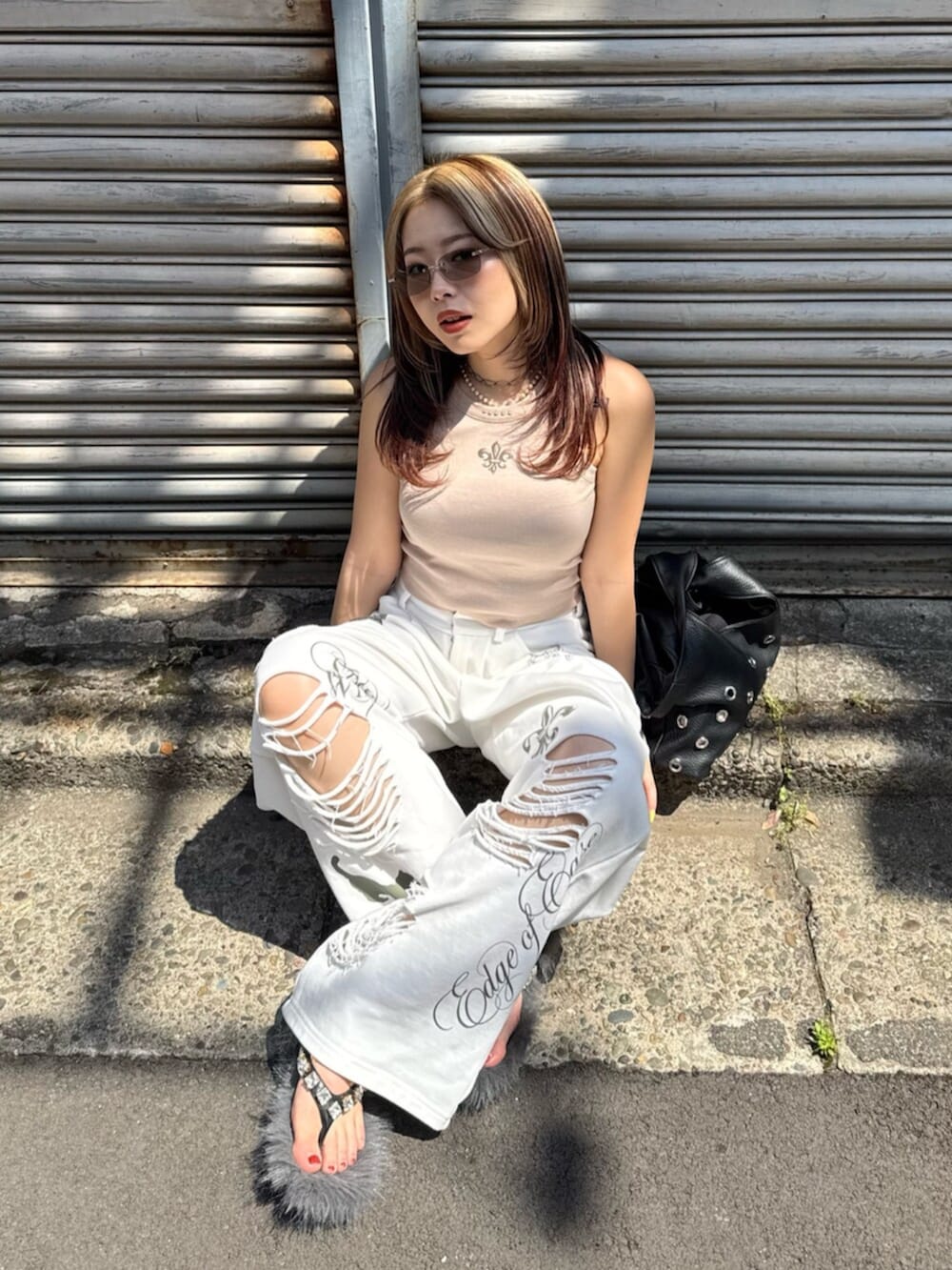 ベージュ系のタンクトップ、ホワイト系のスウェットパンツ、ブラック系のサンダルを着用したレディースの夏コーディネートの4枚目の写真