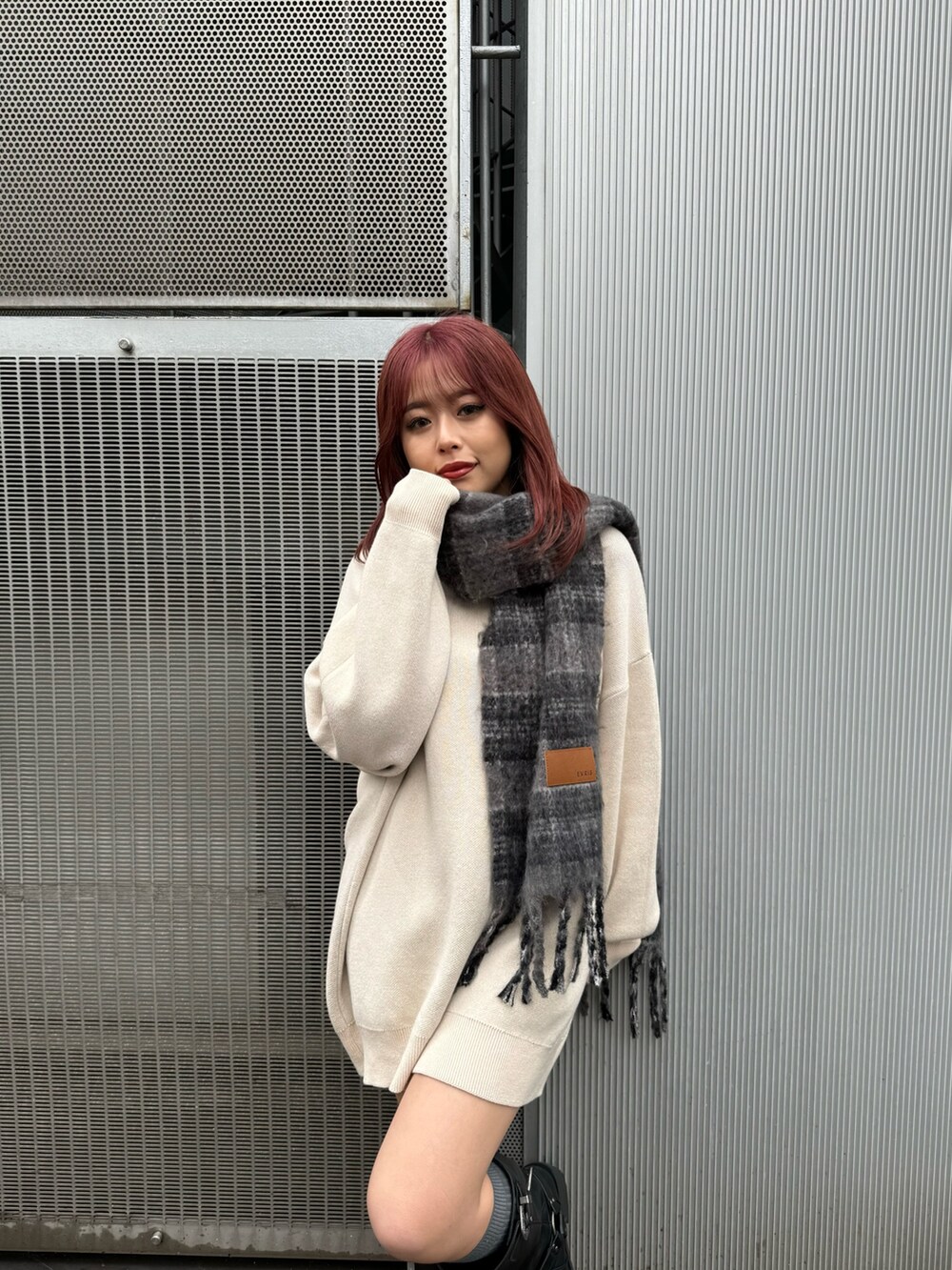 ホワイト系のニット/セーター、ブラック系のブーツ、グレー系のマフラーを着用したレディースの秋コーディネートの3枚目の写真