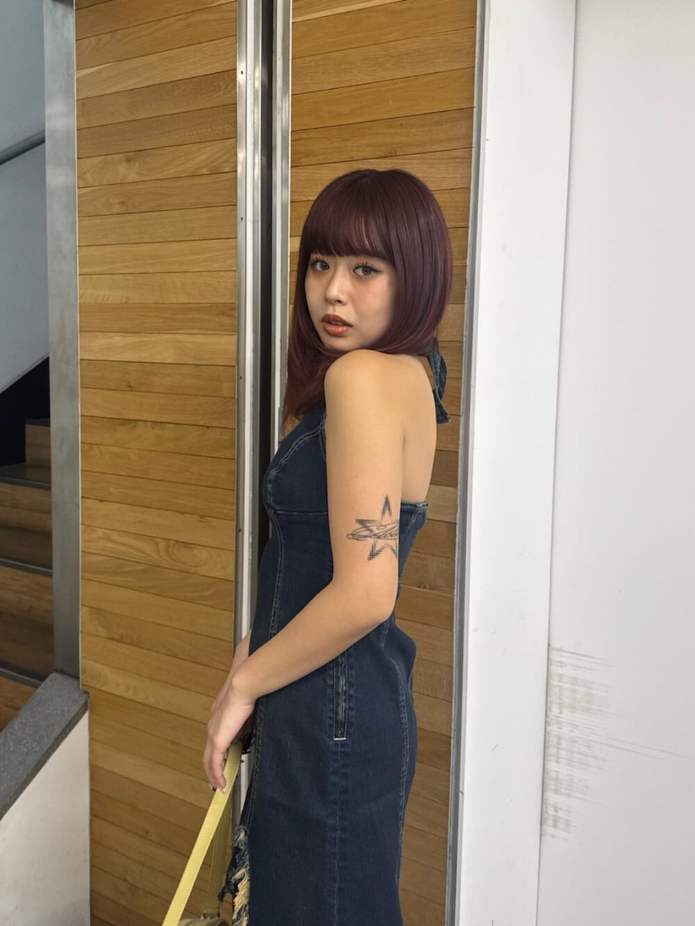 ブルー系のワンピース、イエロー系のハンドバッグ、ホワイト系のサンダルを着用したレディースの春コーディネートの5枚目の写真