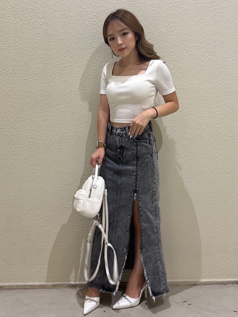 ホワイト系のバックパック/リュック、ブラック系のデニムスカート、ホワイト系のパンプスを着用したレディースの夏コーディネートの6枚目の写真