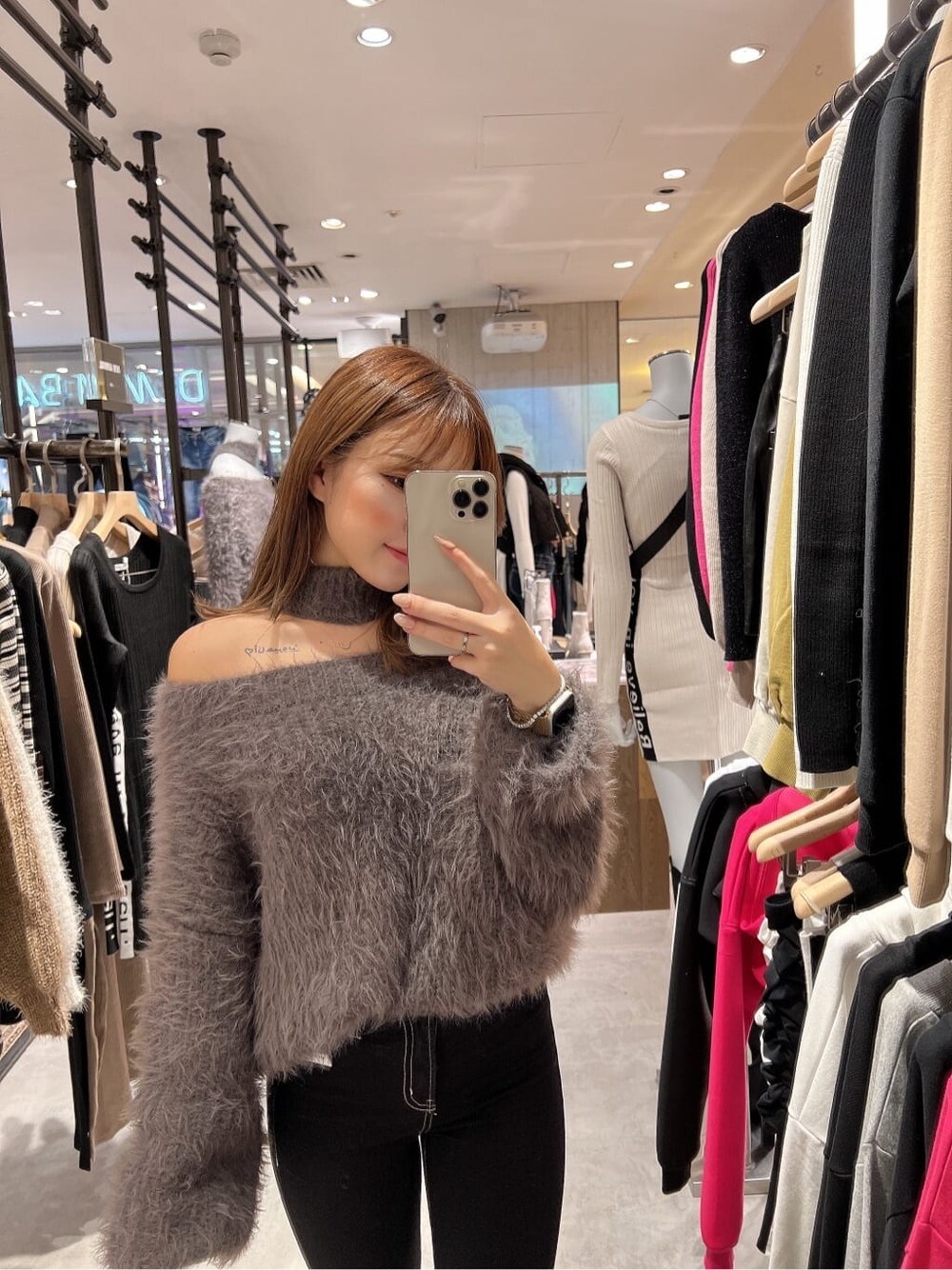 ブラック系のデニムパンツ、グレー系のニット/セーター、ブラック系のブーツを着用したレディースの秋コーディネートの2枚目の写真