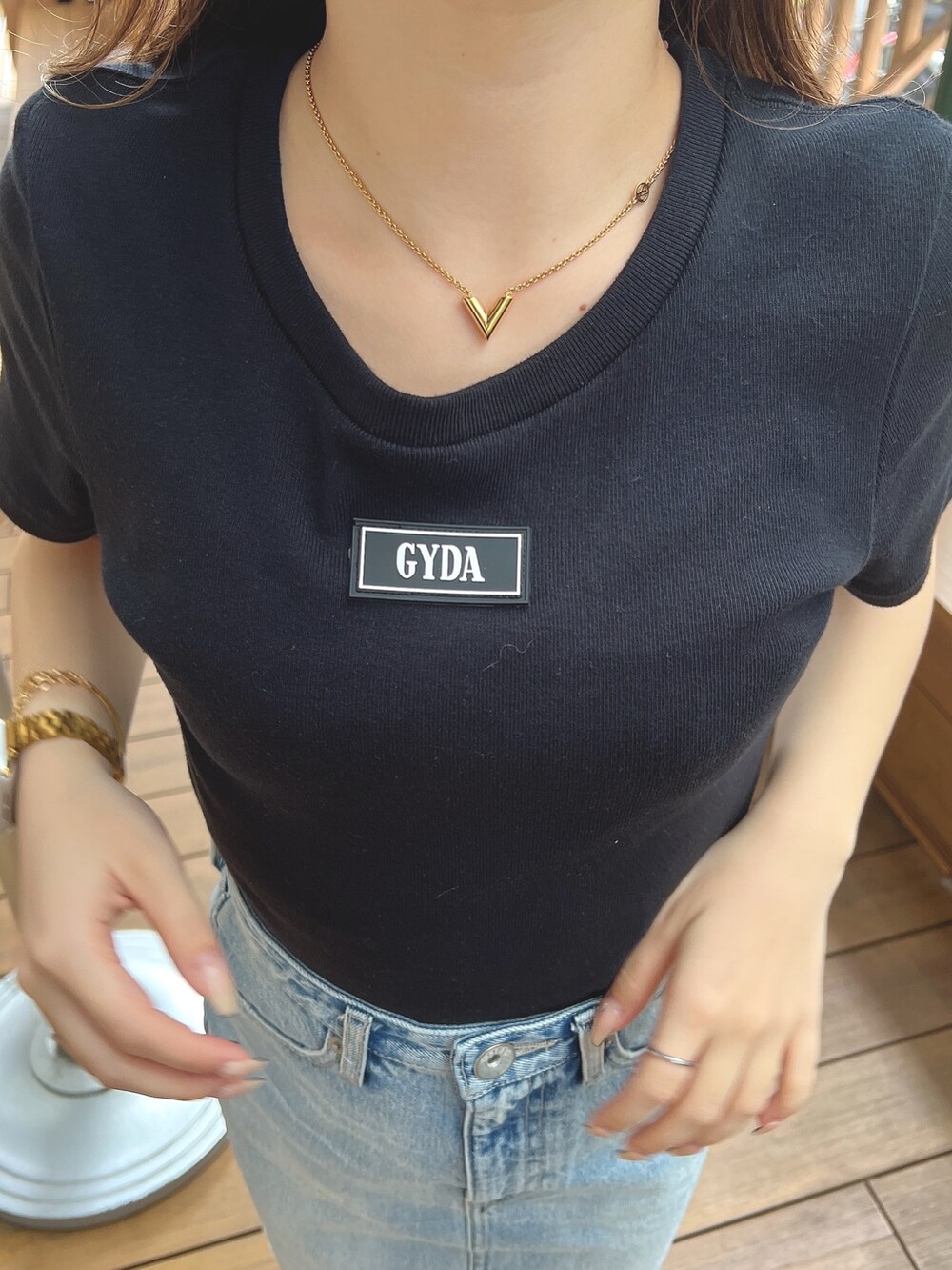 ブラック系のTシャツ/カットソー、ブルー系のデニムスカート、ベージュ系のハットを着用したレディースの春コーディネートの6枚目の写真