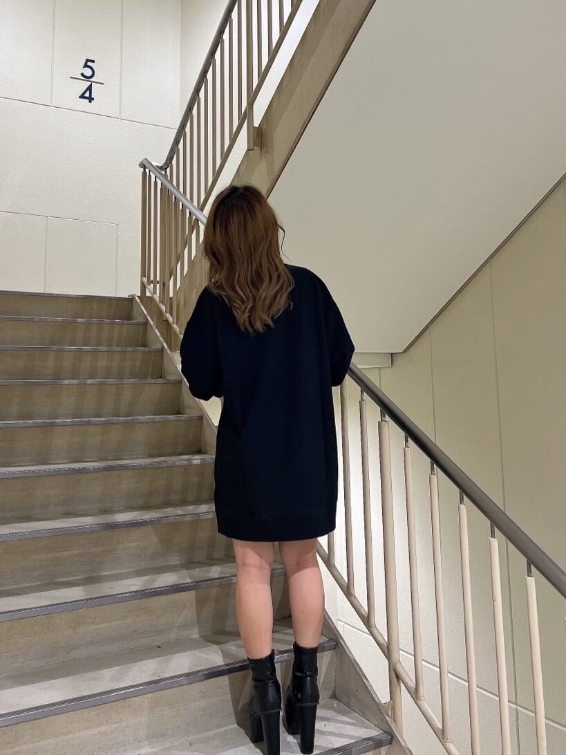 ブラック系のTシャツ/カットソー、ブルー系のデニムパンツ、ブラック系のブーツを着用したレディースの秋コーディネートの2枚目の写真