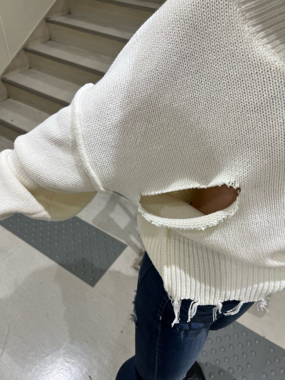 ブルー系のデニムパンツ、ホワイト系のニット/セーター、ブラック系のブーツを着用したレディースの冬コーディネートの6枚目の写真