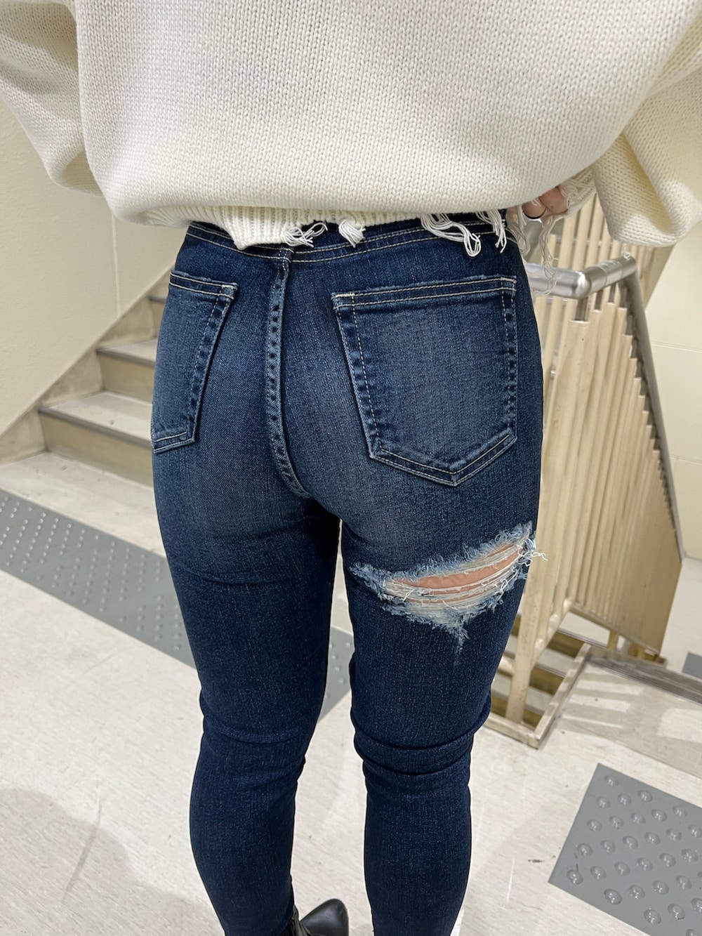 ブルー系のデニムパンツ、ホワイト系のニット/セーター、ブラック系のブーツを着用したレディースの冬コーディネートの7枚目の写真