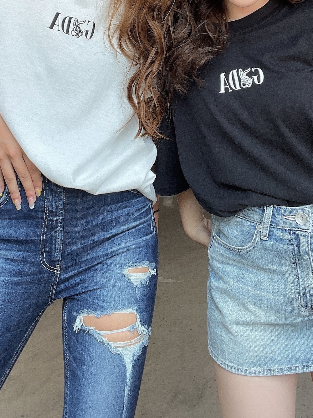 ブラック系のTシャツ/カットソー、ブルー系のデニムスカート、ホワイト系のサンダルを着用したレディースの夏コーディネートの5枚目の写真