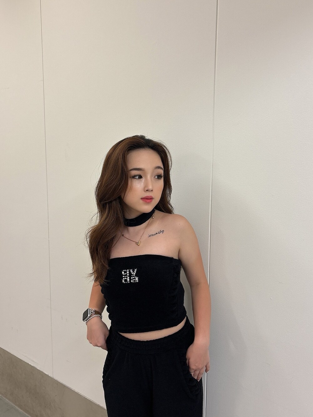 ブラック系のチューブトップ、ブラック系のその他パンツ、ホワイト系のパンプスを着用したレディースの春コーディネートの6枚目の写真