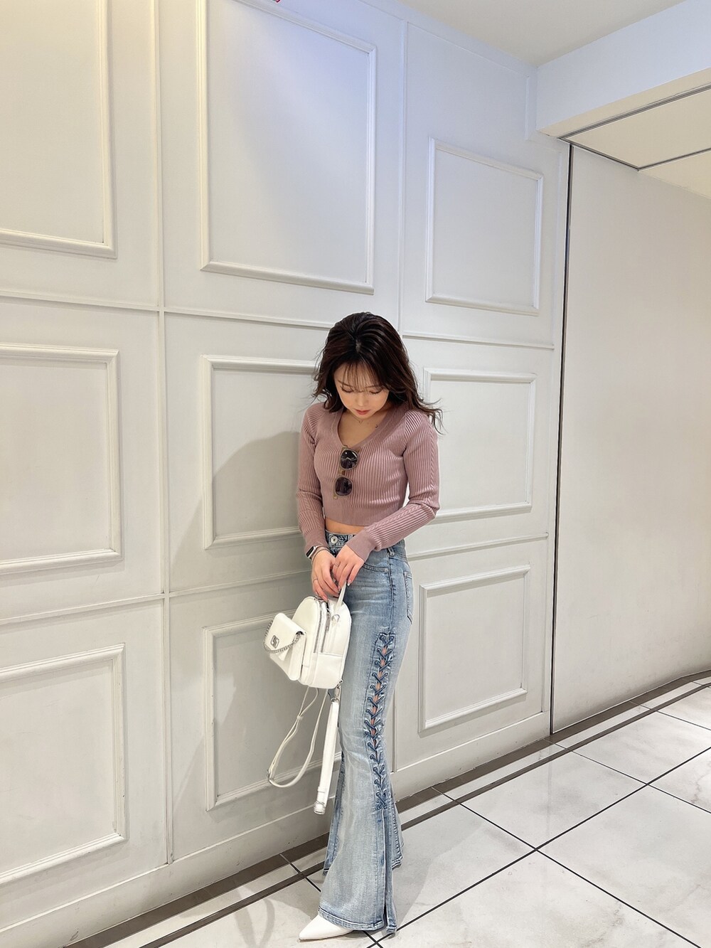 ピンク系のニット/セーター、ブルー系のデニムパンツ、ホワイト系のバックパック/リュックを着用したレディースの冬コーディネートの5枚目の写真