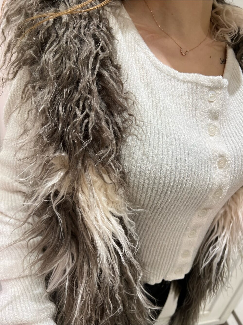 ホワイト系のカーディガン/ボレロ、ブラック系のブーツ、その他のベストを着用したレディースの秋コーディネートの5枚目の写真