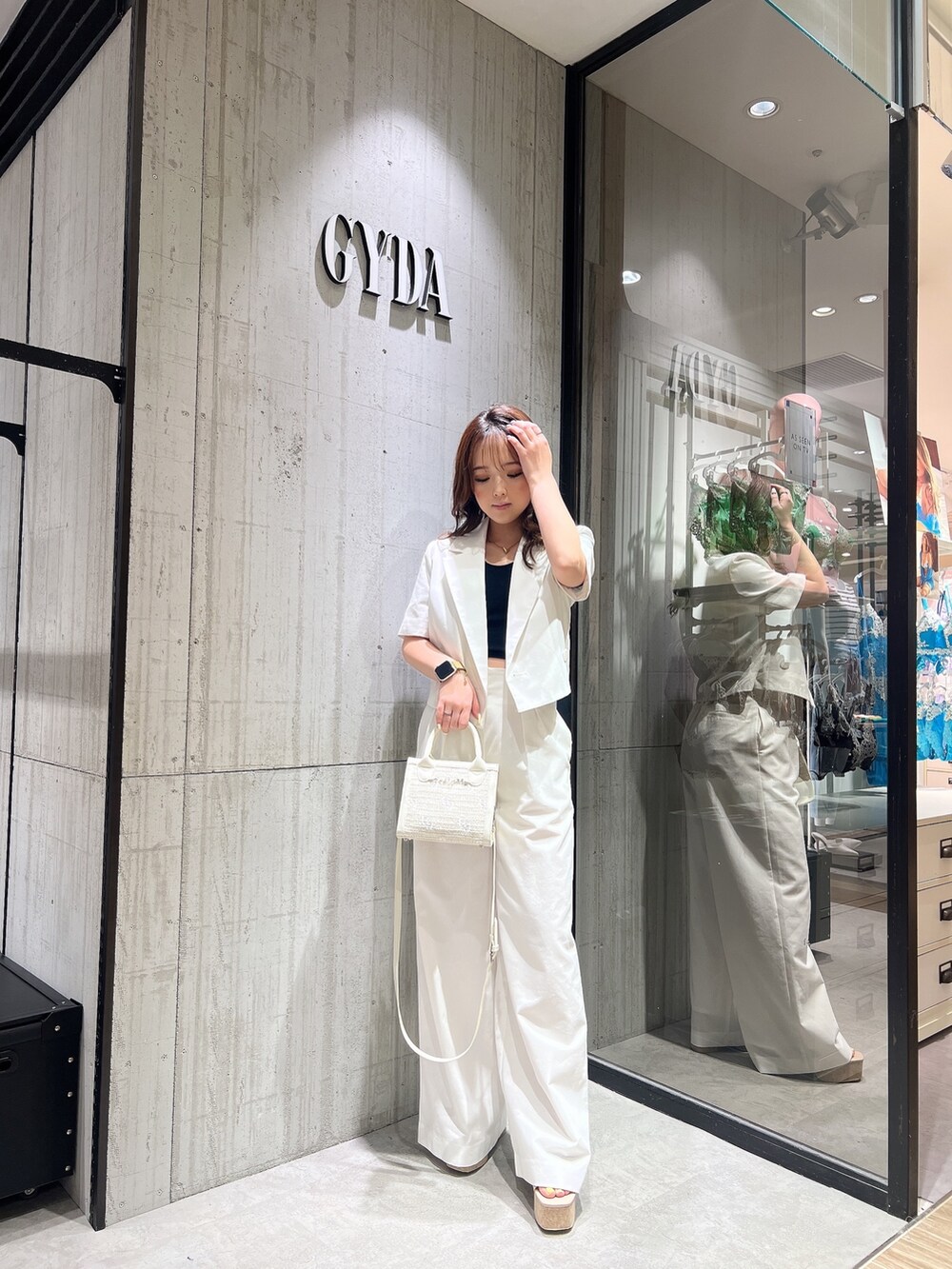 ホワイト系のテーラードジャケット、ホワイト系のスラックス、ホワイト系のサンダルを着用したレディースの春コーディネートの4枚目の写真