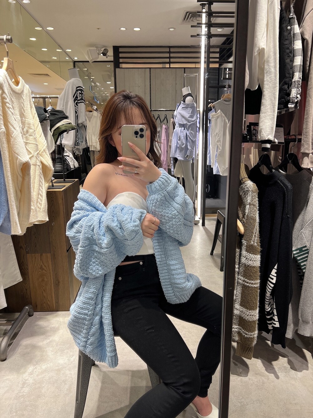 ブルー系のカーディガン/ボレロ、ホワイト系のチューブトップ、ブラック系のデニムパンツを着用したレディースの春コーディネートの3枚目の写真