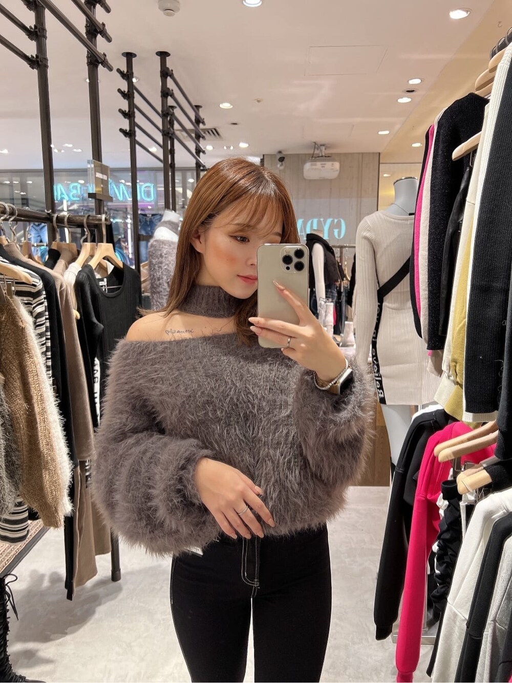 ブラック系のデニムパンツ、グレー系のニット/セーター、ブラック系のブーツを着用したレディースの秋コーディネートの3枚目の写真