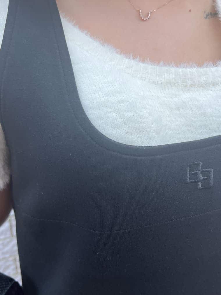 ホワイト系のニット/セーター、ブラック系のハンドバッグ、ブラック系のブーツを着用したレディースの夏コーディネートの5枚目の写真