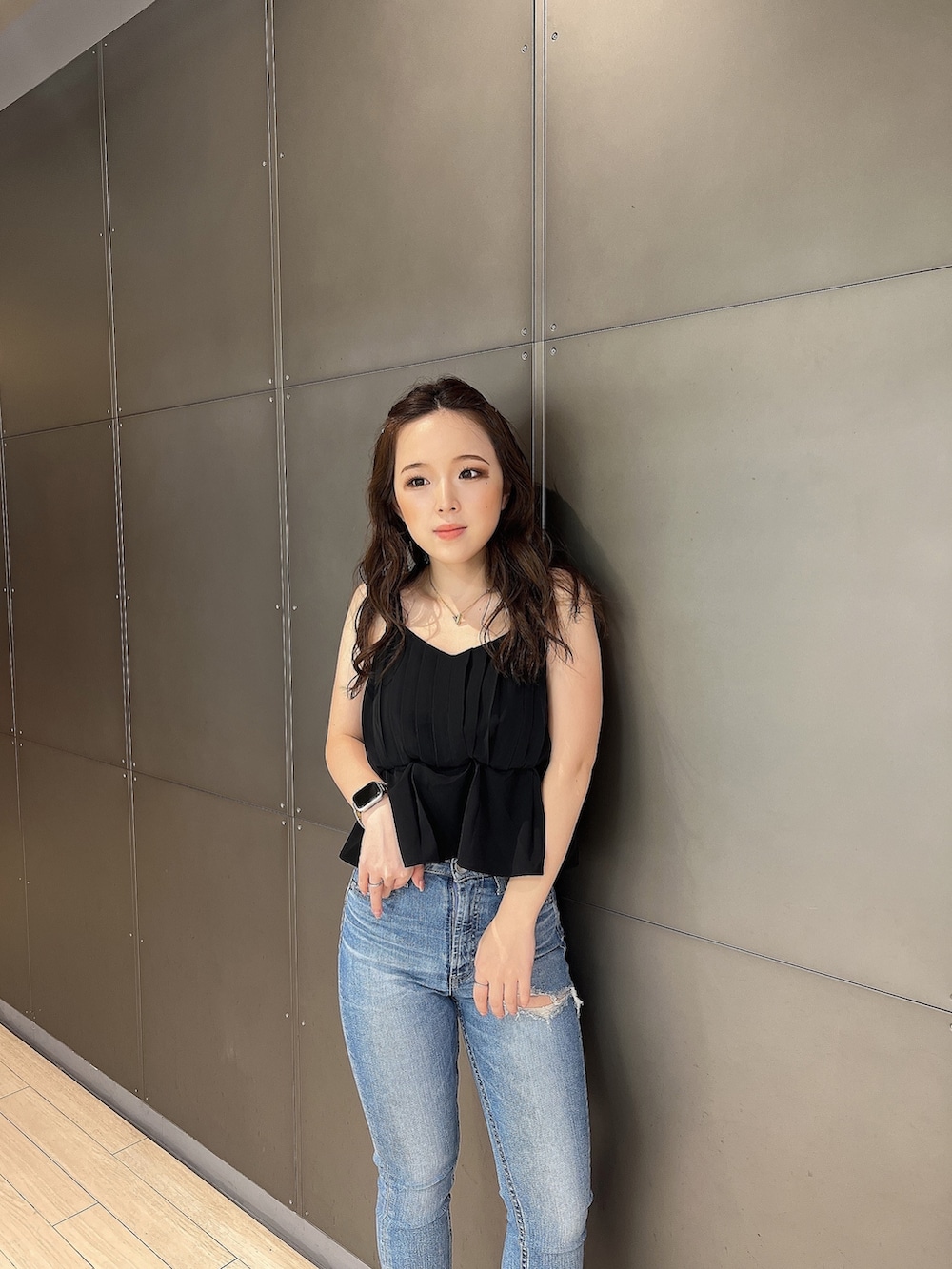 ブラック系のキャミソール、ブルー系のデニムパンツ、ホワイト系のサンダルを着用したレディースの夏コーディネートの5枚目の写真