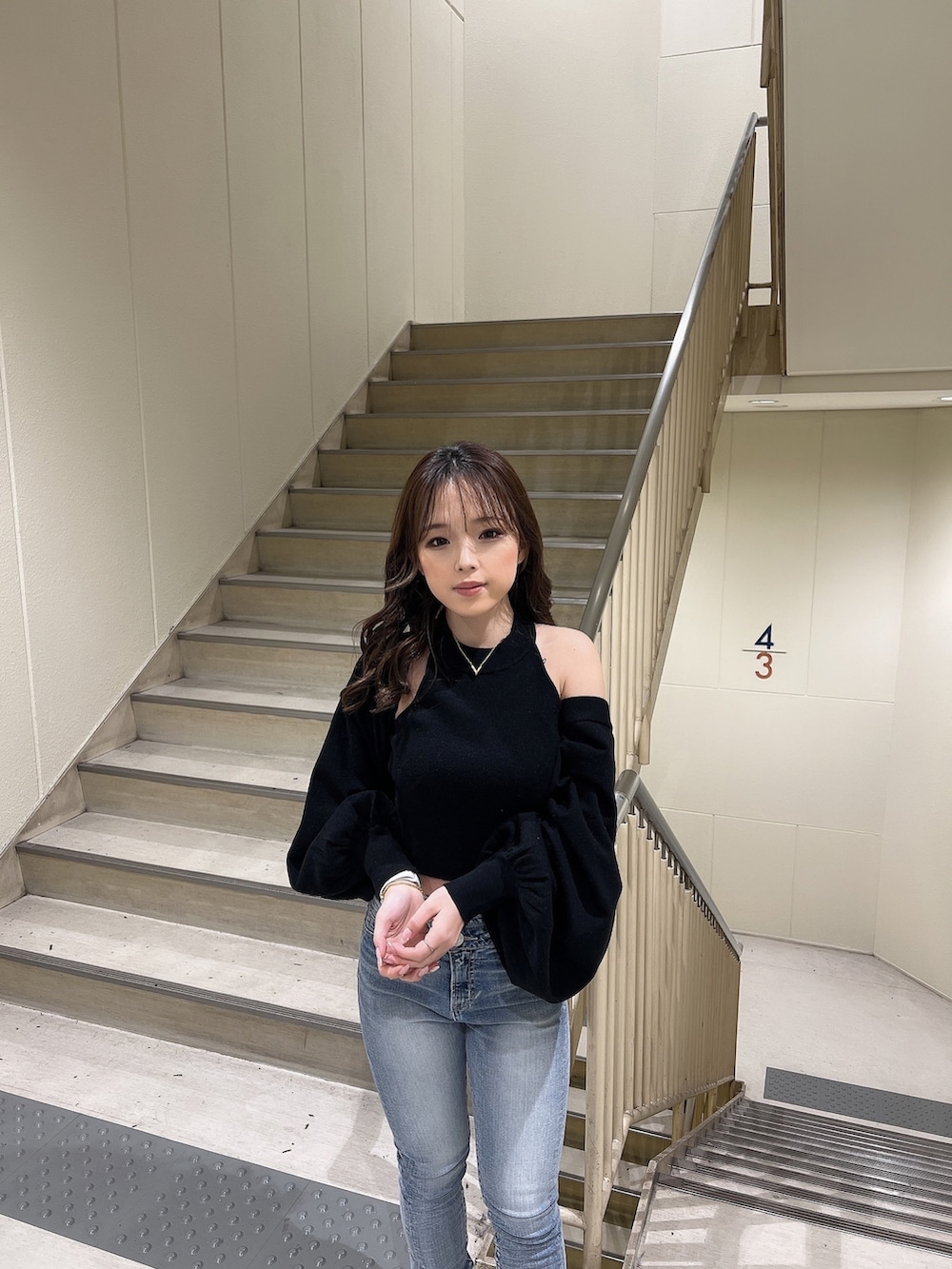 ブラック系のカーディガン/ボレロ、ブルー系のデニムパンツ、ブラック系のブーツを着用したレディースの冬コーディネートの6枚目の写真