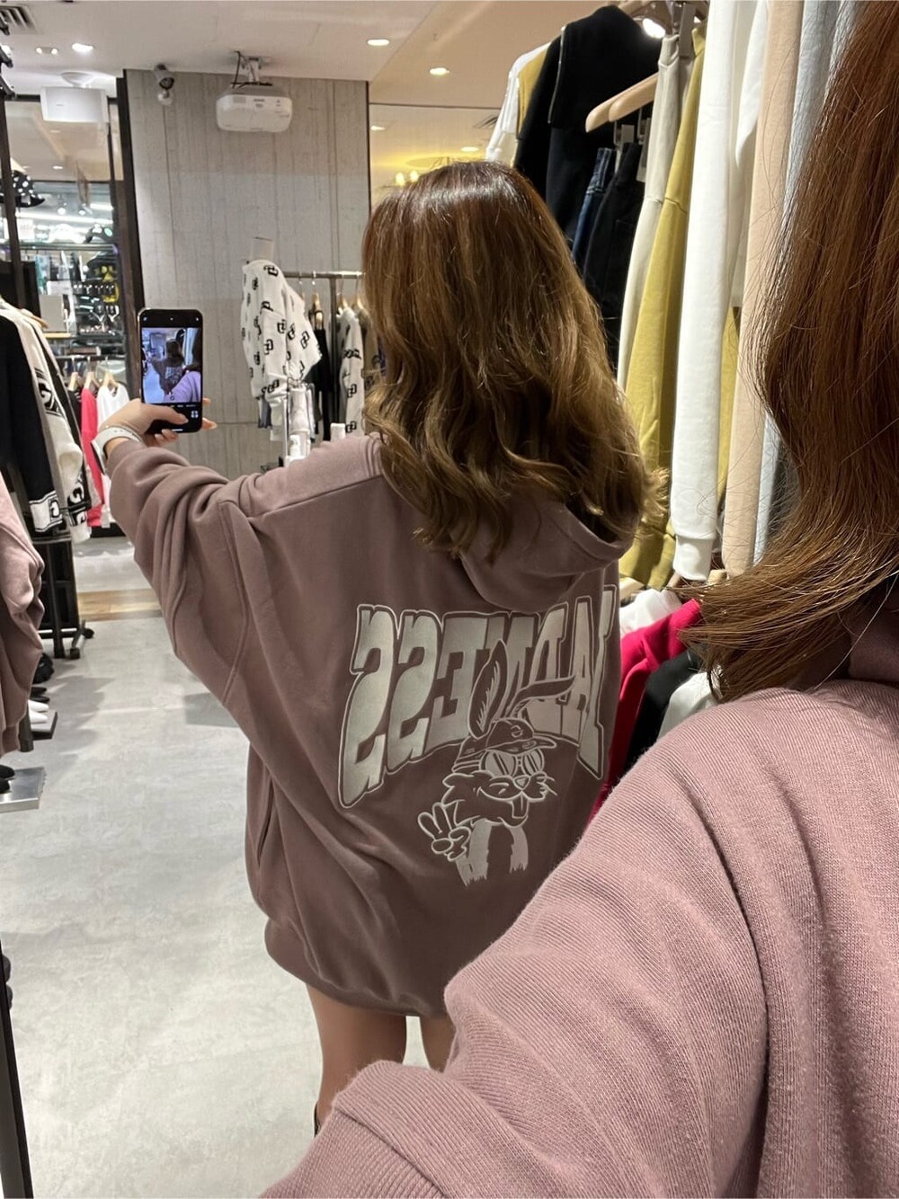 ブラック系のブーツ、ピンク系のパーカーを着用したレディースの秋コーディネートの3枚目の写真