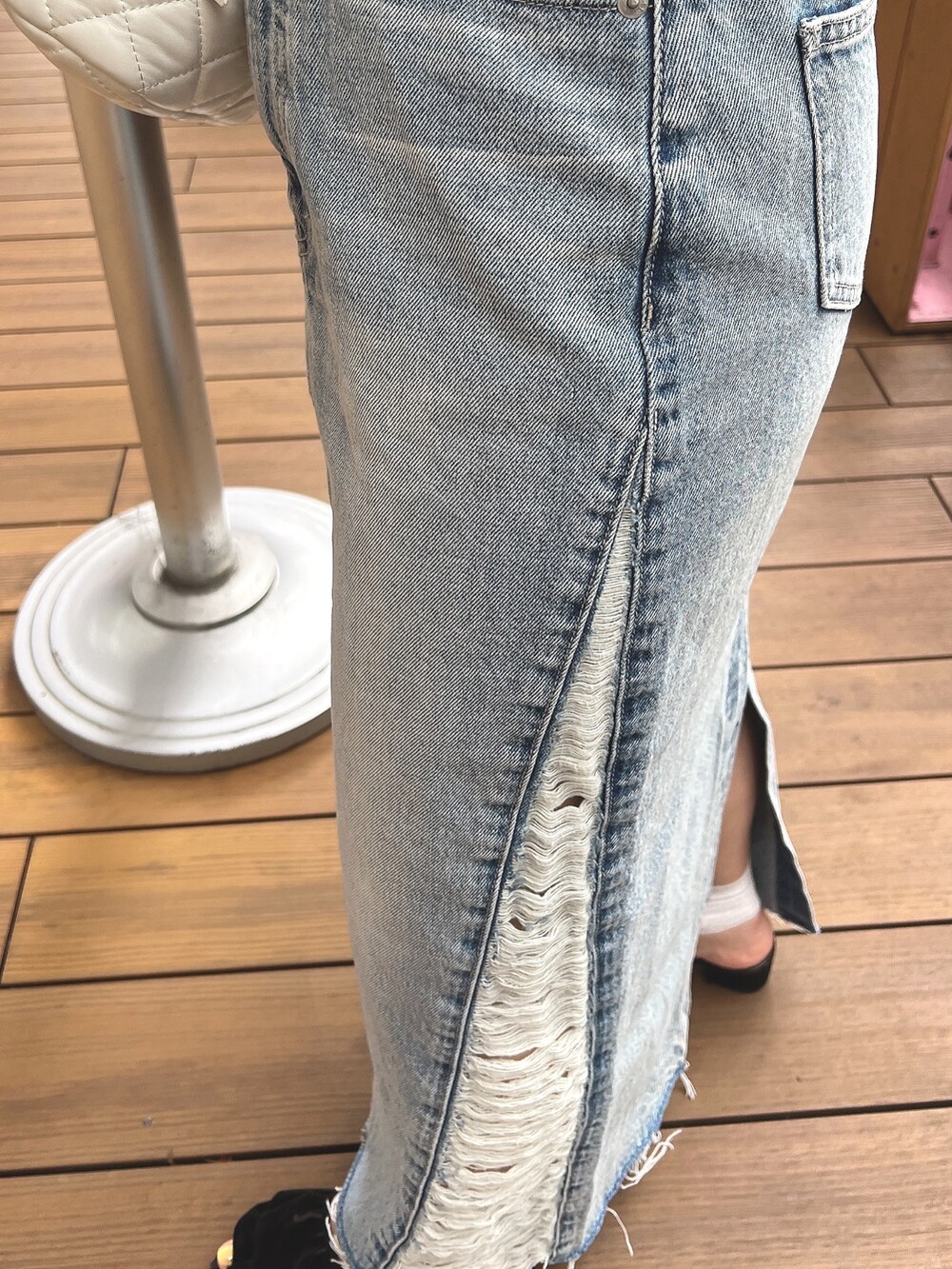 ブラック系のTシャツ/カットソー、ブルー系のデニムスカート、ベージュ系のハットを着用したレディースの春コーディネートの7枚目の写真