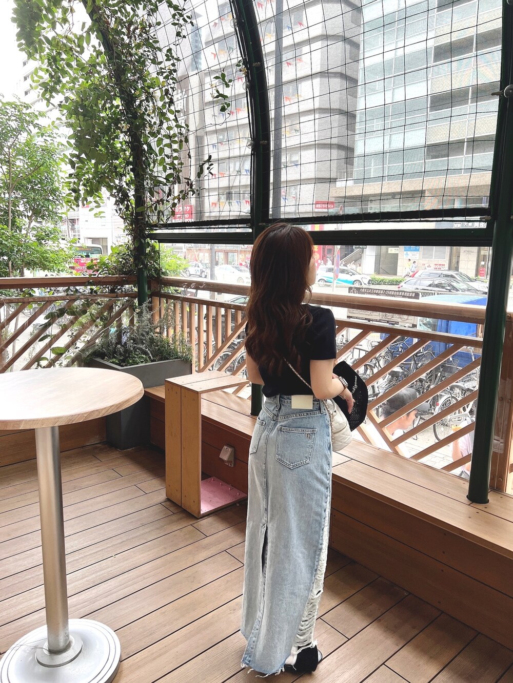 ブラック系のTシャツ/カットソー、ブルー系のデニムスカート、ベージュ系のハットを着用したレディースの春コーディネートの3枚目の写真