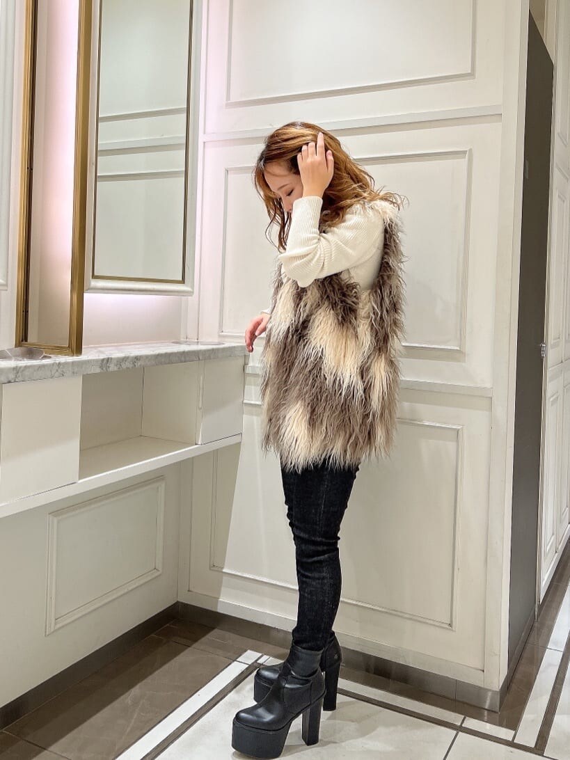 ホワイト系のカーディガン/ボレロ、ブラック系のブーツ、その他のベストを着用したレディースの秋コーディネートの3枚目の写真