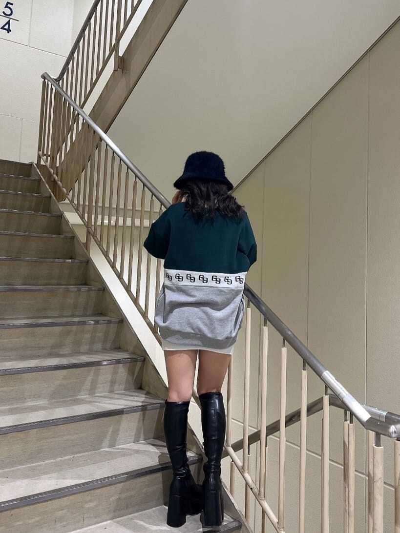 ブラック系のブーツ、ホワイト系のワンピース、グリーン系のスウェットを着用したレディースの秋コーディネートの5枚目の写真