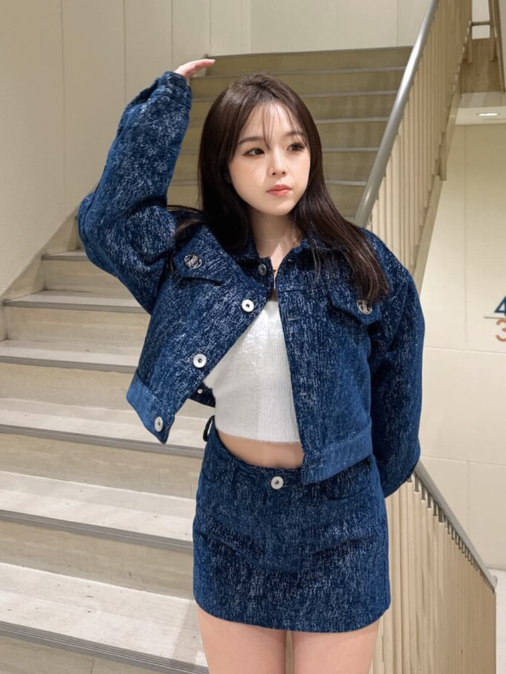 ブルー系のデニムジャケット、ブルー系のスカート、ホワイト系のキャミソールを着用したレディースの冬コーディネートの4枚目の写真