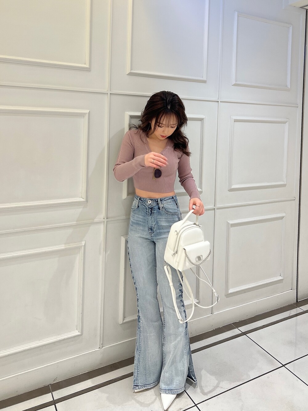 ピンク系のニット/セーター、ブルー系のデニムパンツ、ホワイト系のバックパック/リュックを着用したレディースの冬コーディネートの3枚目の写真