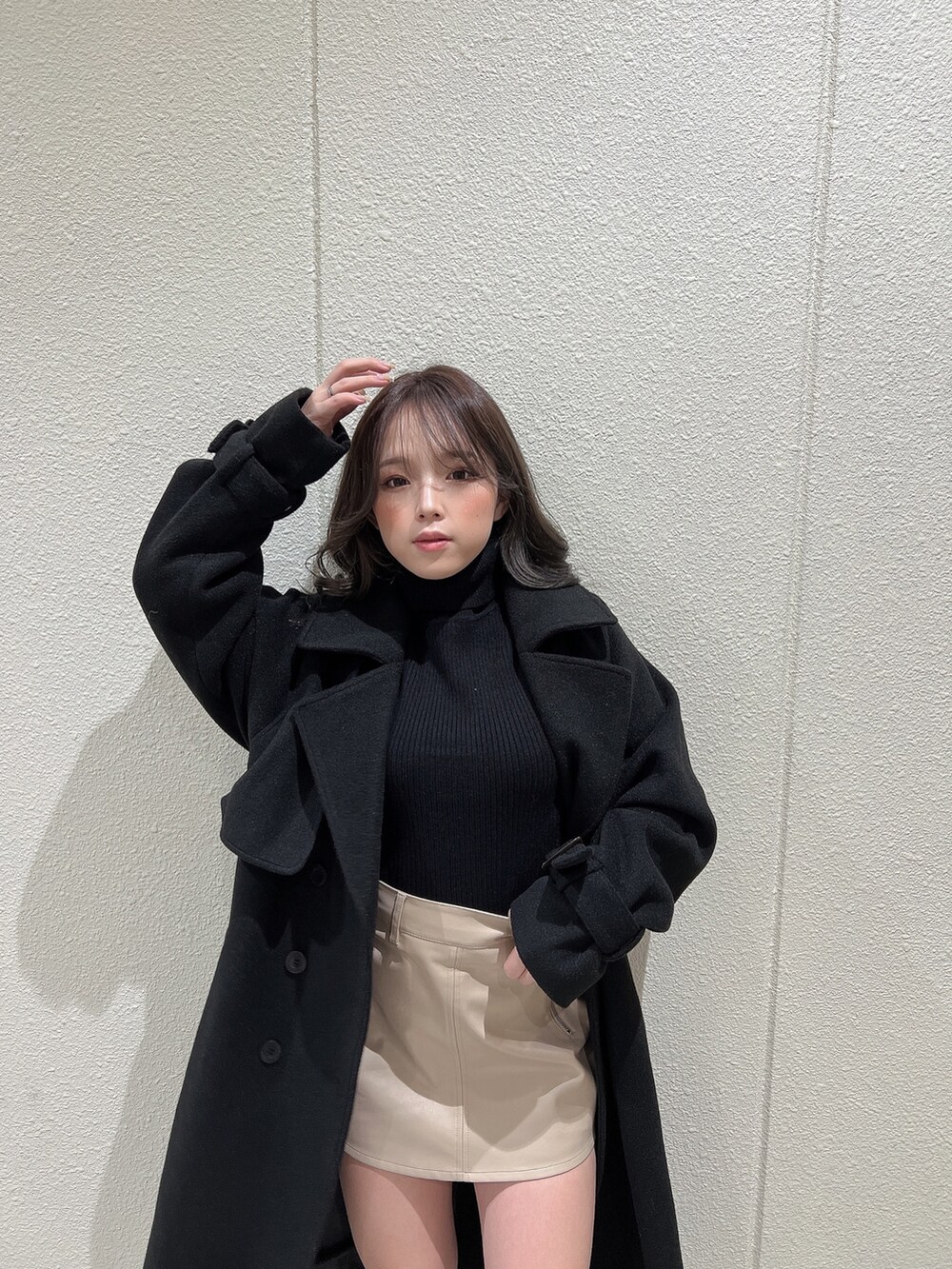 ブラック系のニット/セーター、ブラック系のトレンチコート、ブラック系のブーツを着用したレディースの冬コーディネートの4枚目の写真