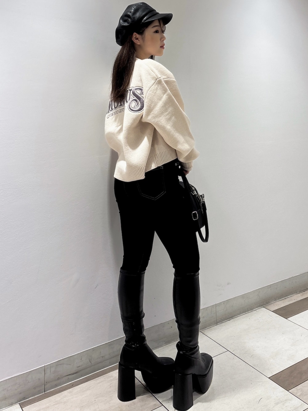 ピンク系のニット/セーター、ブラック系のブーツ、ブラック系のバックパック/リュックを着用したレディースの秋コーディネートの3枚目の写真