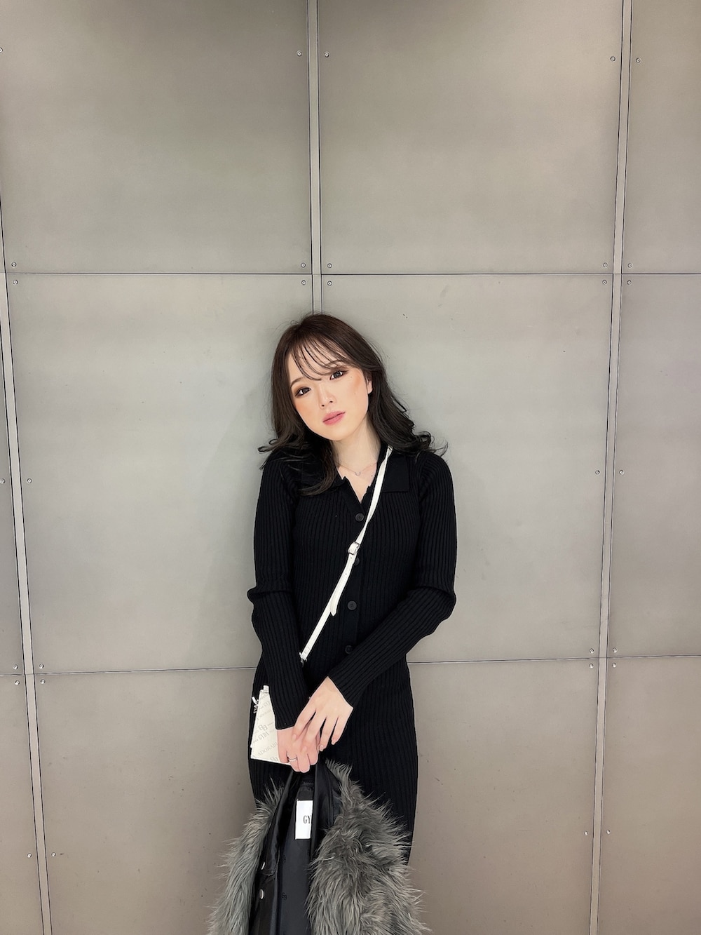 グレー系のライダースジャケット、ブラック系のワンピース、ブラック系のブーツを着用したレディースの冬コーディネートの5枚目の写真