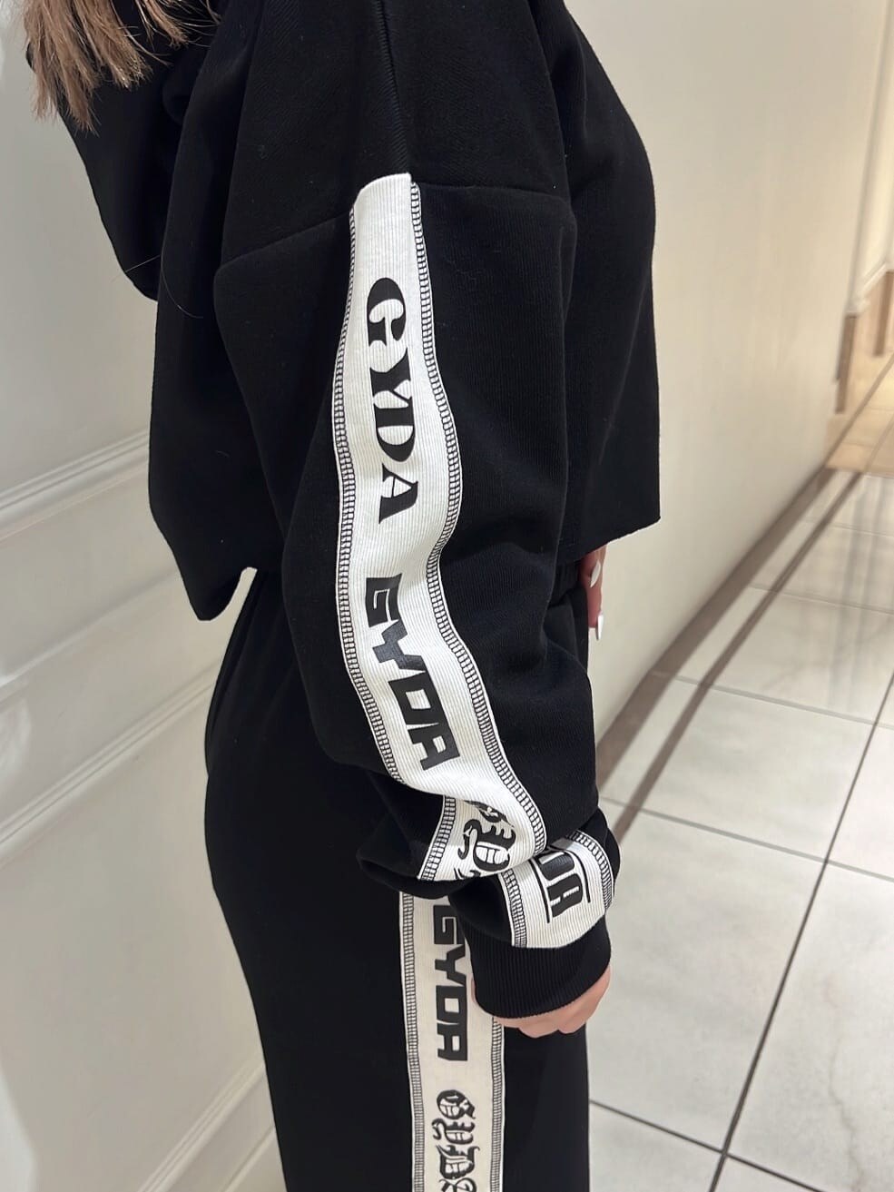 ホワイト系のパンプス、ブラック系のその他パンツ、ブラック系のパーカーを着用したレディースの夏コーディネートの6枚目の写真