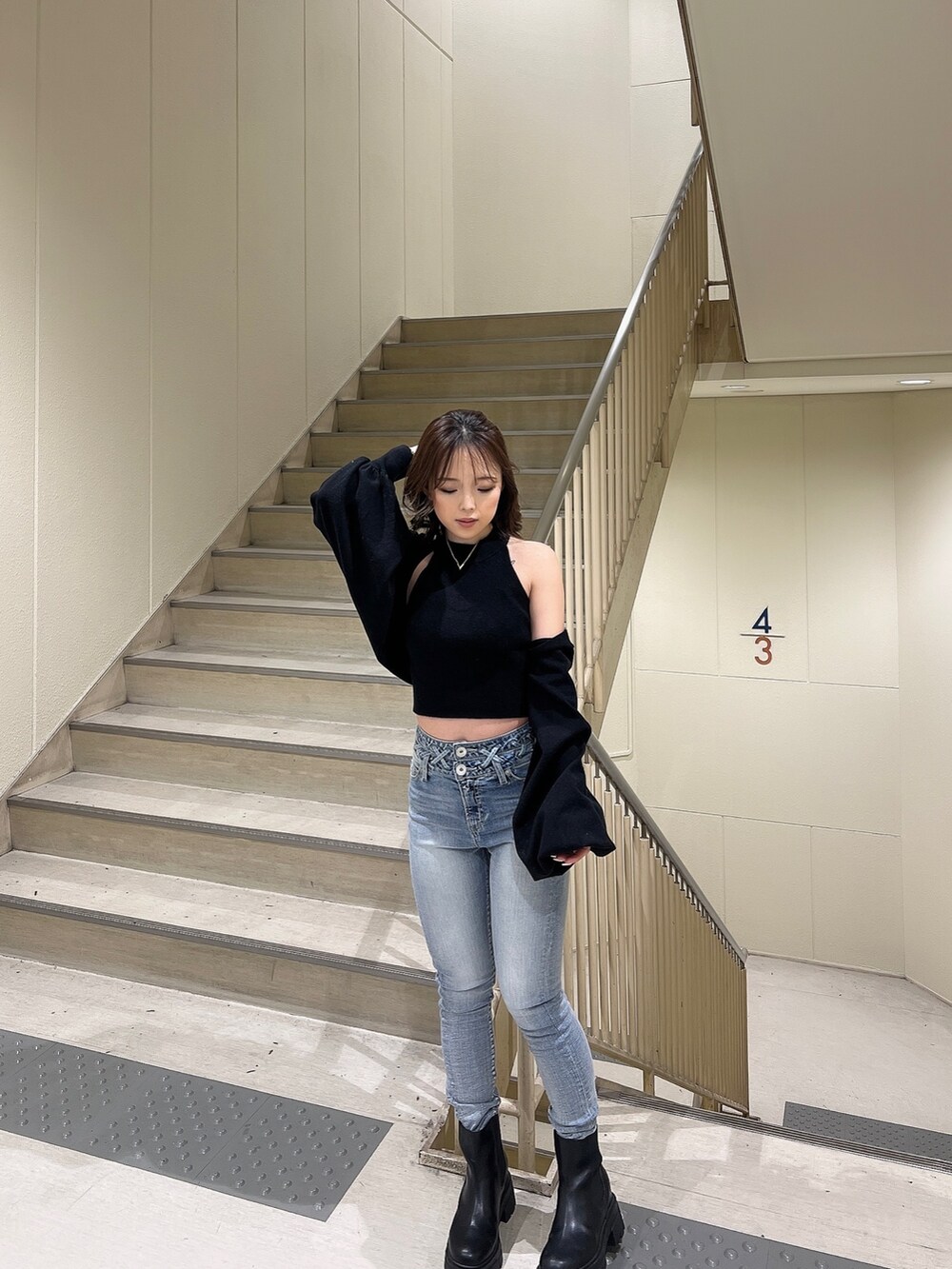 ブラック系のカーディガン/ボレロ、ブルー系のデニムパンツ、ブラック系のブーツを着用したレディースの冬コーディネートの5枚目の写真