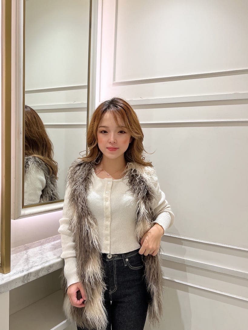 ホワイト系のカーディガン/ボレロ、ブラック系のブーツ、その他のベストを着用したレディースの秋コーディネートの4枚目の写真