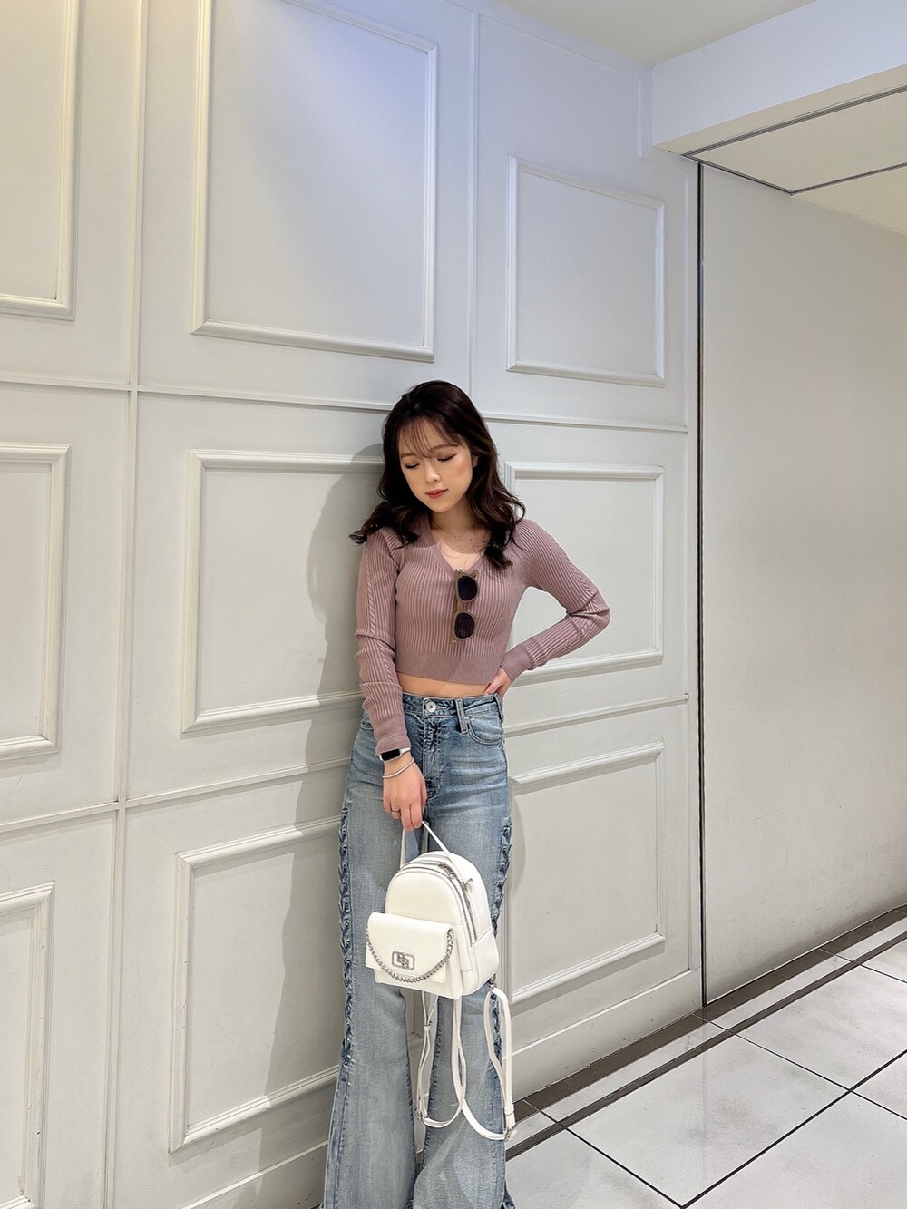 ピンク系のニット/セーター、ブルー系のデニムパンツ、ホワイト系のバックパック/リュックを着用したレディースの冬コーディネートの4枚目の写真