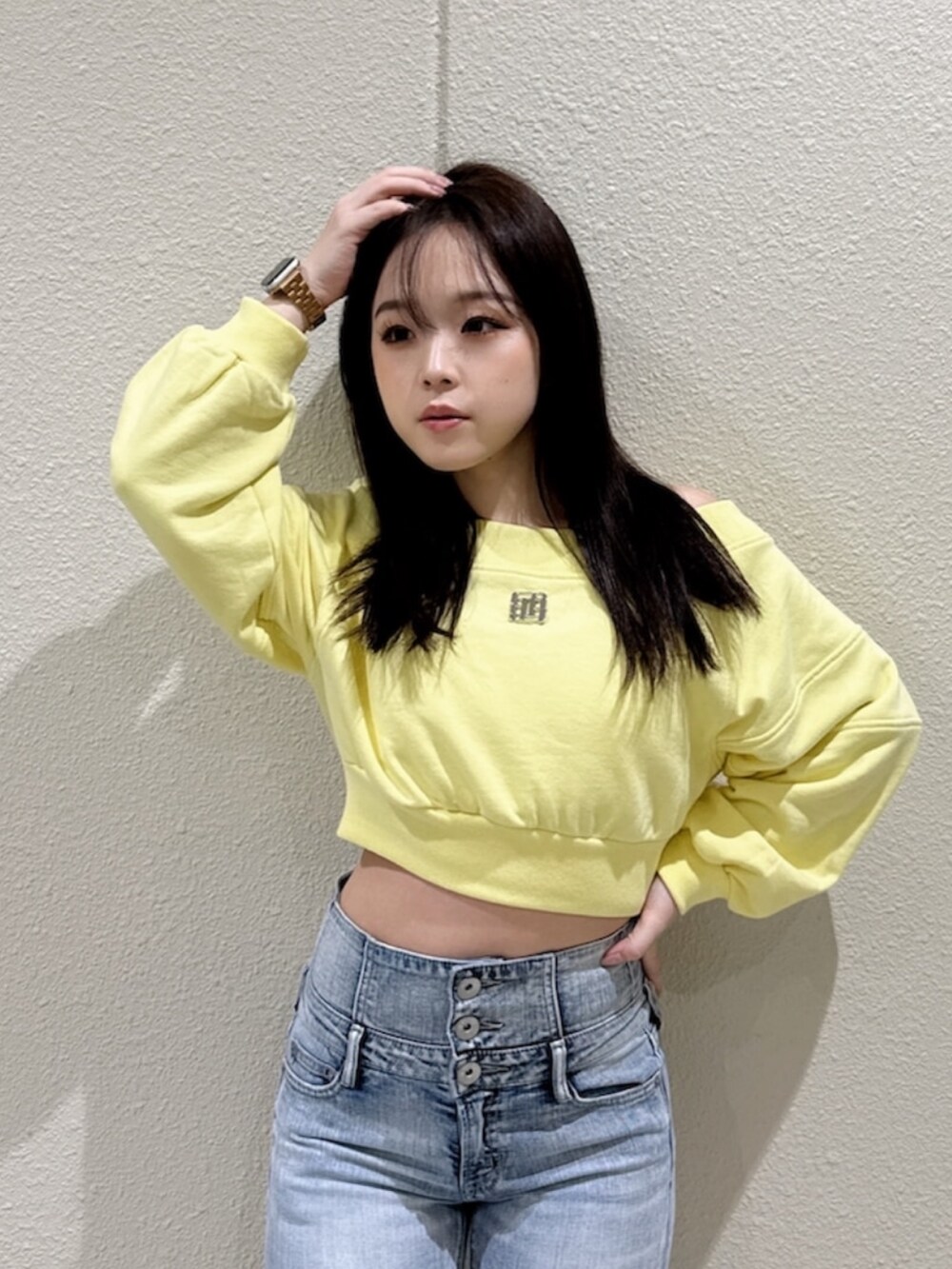 ブルー系のデニムパンツ、イエロー系のスウェット、ブラック系のブーツを着用したレディースの冬コーディネートの4枚目の写真