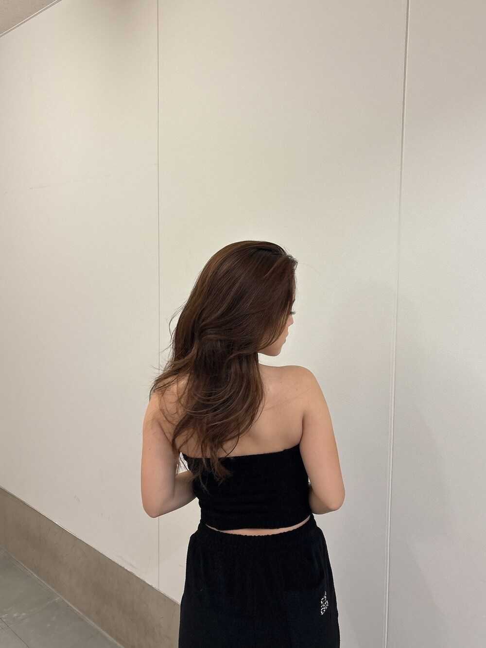 ブラック系のチューブトップ、ブラック系のその他パンツ、ホワイト系のパンプスを着用したレディースの春コーディネートの5枚目の写真