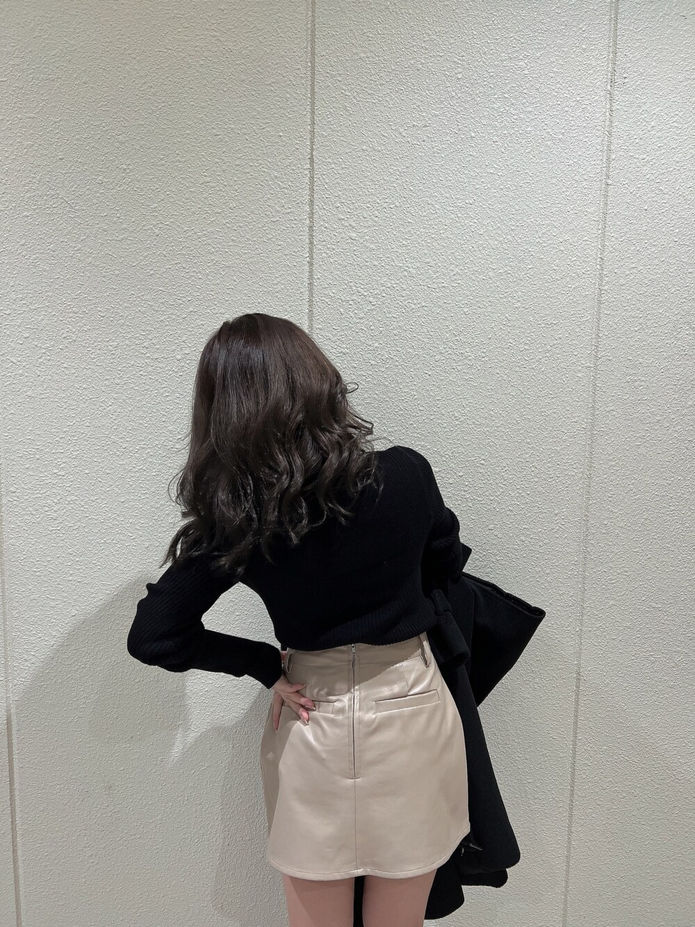 ブラック系のニット/セーター、ブラック系のトレンチコート、ブラック系のブーツを着用したレディースの冬コーディネートの8枚目の写真