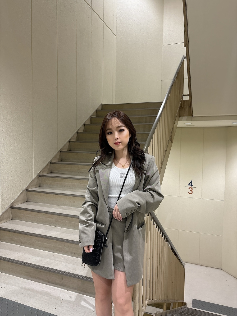 ホワイト系のTシャツ/カットソー、ベージュ系のテーラードジャケット、ベージュ系のスカートを着用したレディースの春コーディネートの5枚目の写真