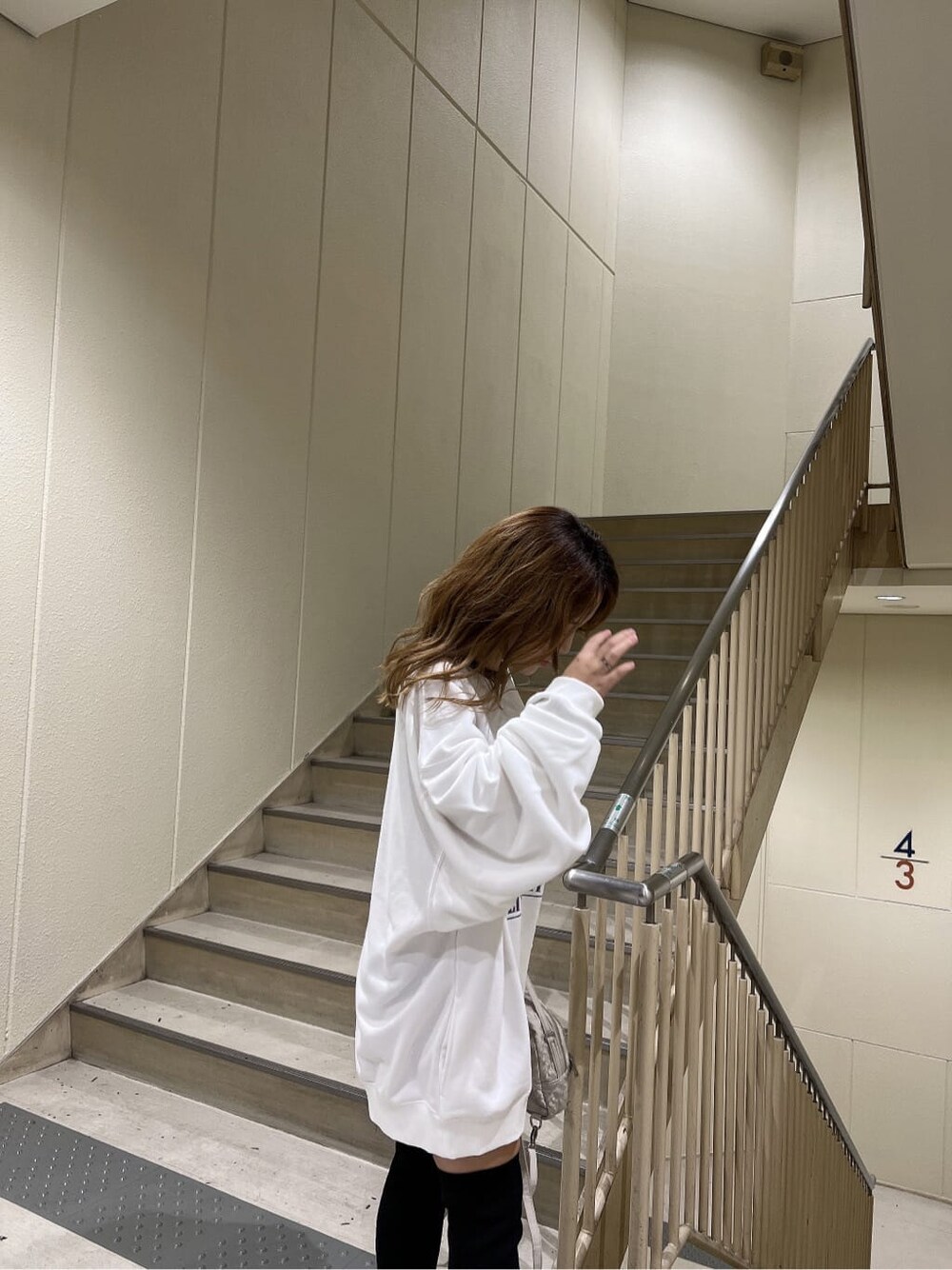 ホワイト系のバックパック/リュック、ブルー系のデニムパンツ、ホワイト系のスウェットを着用したレディースの秋コーディネートの5枚目の写真