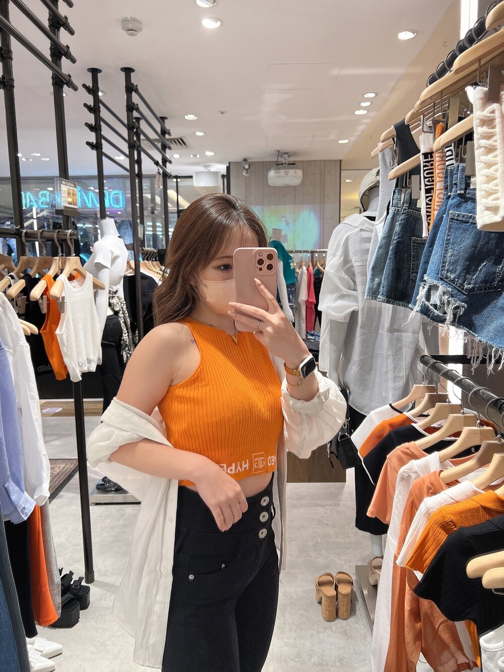 ホワイト系のサンダル、ブラック系のデニムパンツ、オレンジ系のニット/セーターを着用したレディースの春コーディネートの6枚目の写真