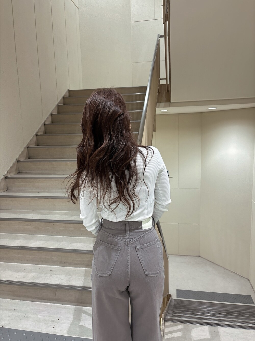 ホワイト系のニット/セーター、ベージュ系のデニムパンツ、ホワイト系のパンプスを着用したレディースの冬コーディネートの3枚目の写真