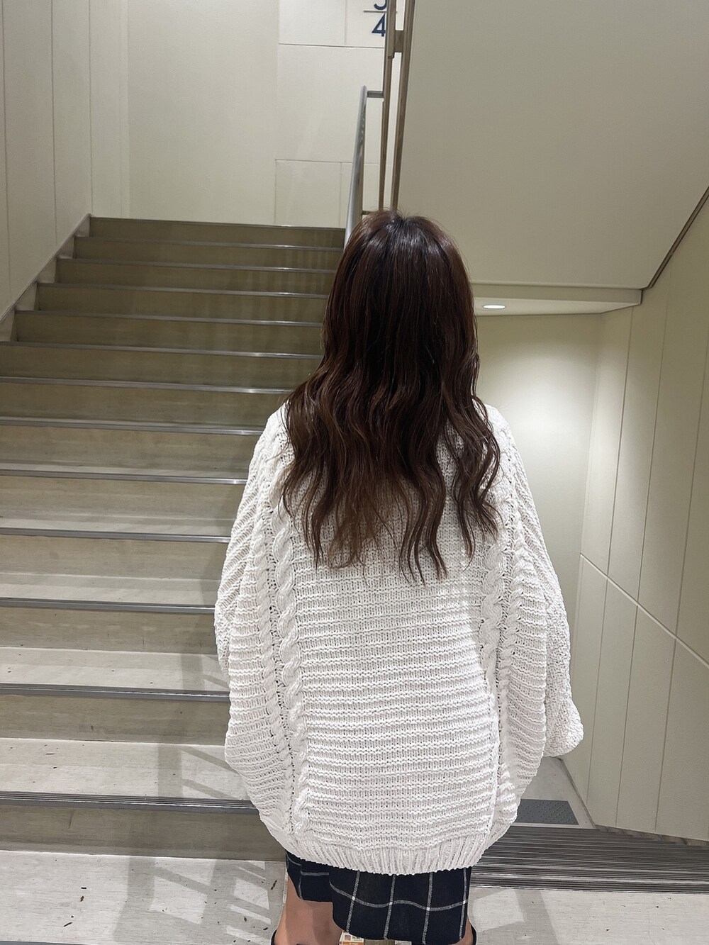 ブルー系のシャツ/ブラウス、ホワイト系のカーディガン/ボレロ、ブラック系のブーツを着用したレディースの秋コーディネートの6枚目の写真