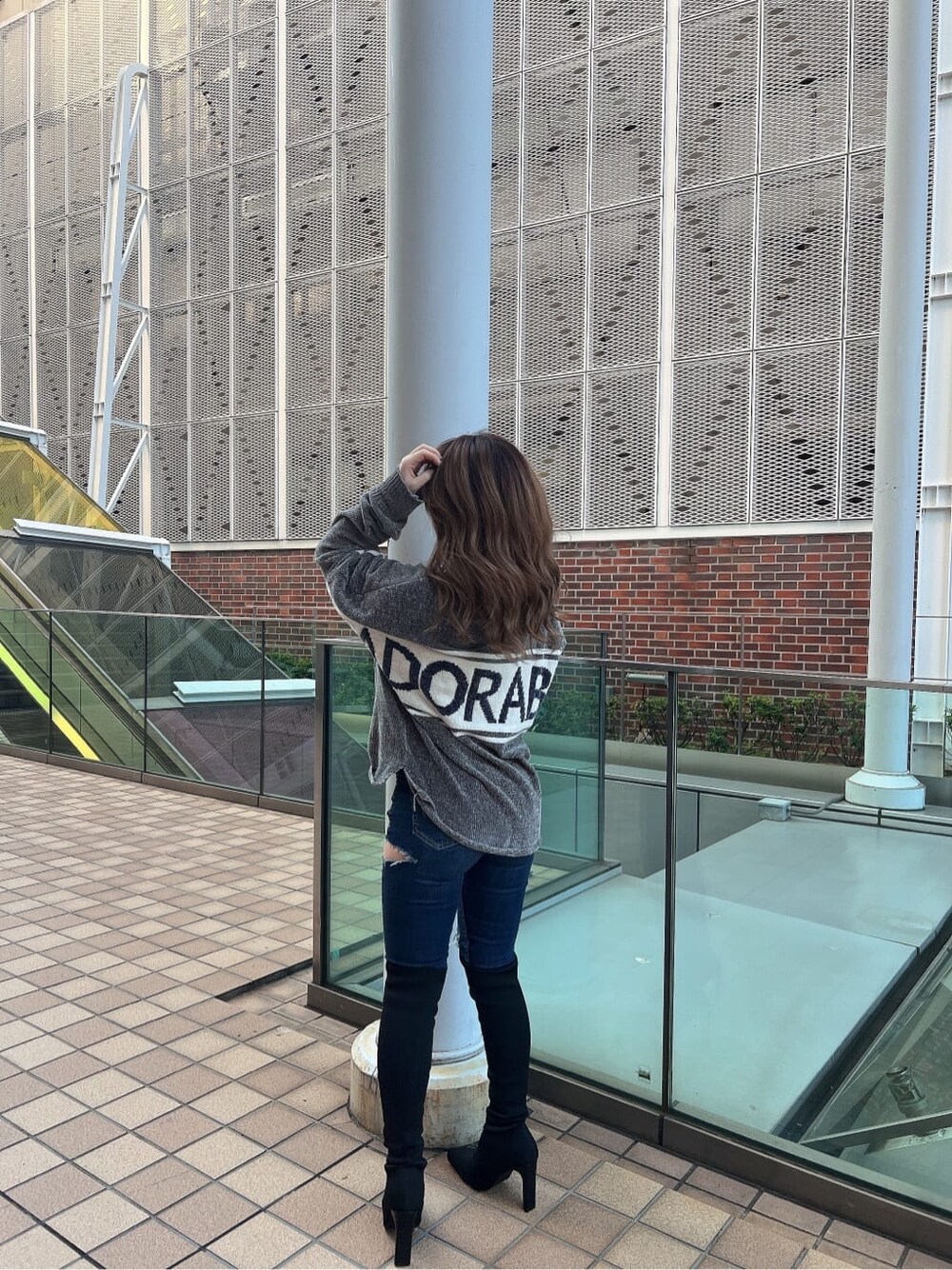 ブルー系のデニムパンツ、ブルー系のデニムパンツ、ブラック系のブーツを着用したレディースの秋コーディネートの2枚目の写真