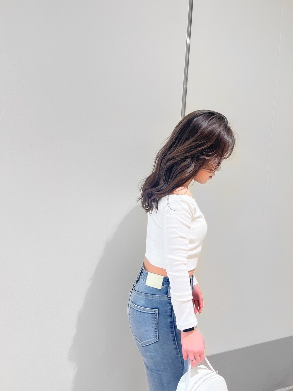 ホワイト系のTシャツ/カットソー、ブルー系のデニムパンツ、ホワイト系のパンプスを着用したレディースの春コーディネートの2枚目の写真