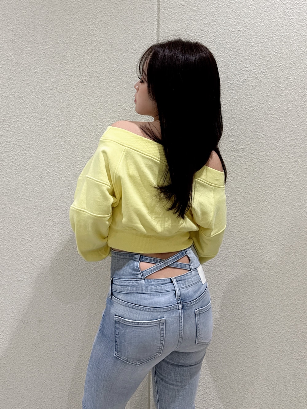 ブルー系のデニムパンツ、イエロー系のスウェット、ブラック系のブーツを着用したレディースの冬コーディネートの5枚目の写真